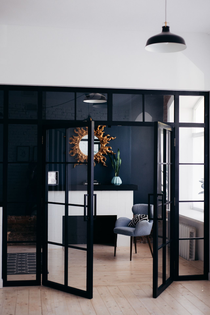 Moderne woonkamer met glazen deur die afgewerkt is met zwarte metalen details